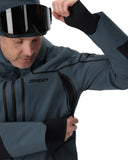 Person wearing a Spyder jacket and goggles on a white background