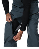 Close-up of dark gray pants with a brand logo on a white background