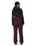 Person wearing a black jacket and maroon pants on a white background
