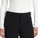Person wearing black pants with a white top on a plain background